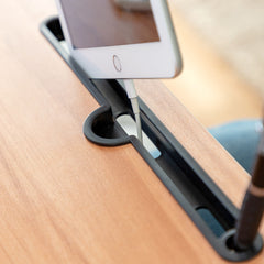 Tablet mit Ladekabel in der Halterille des Muvisk Klapptischs