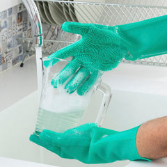 Grüne Silikonhandschuhe reinigen einen Behälter unter fließendem Wasser