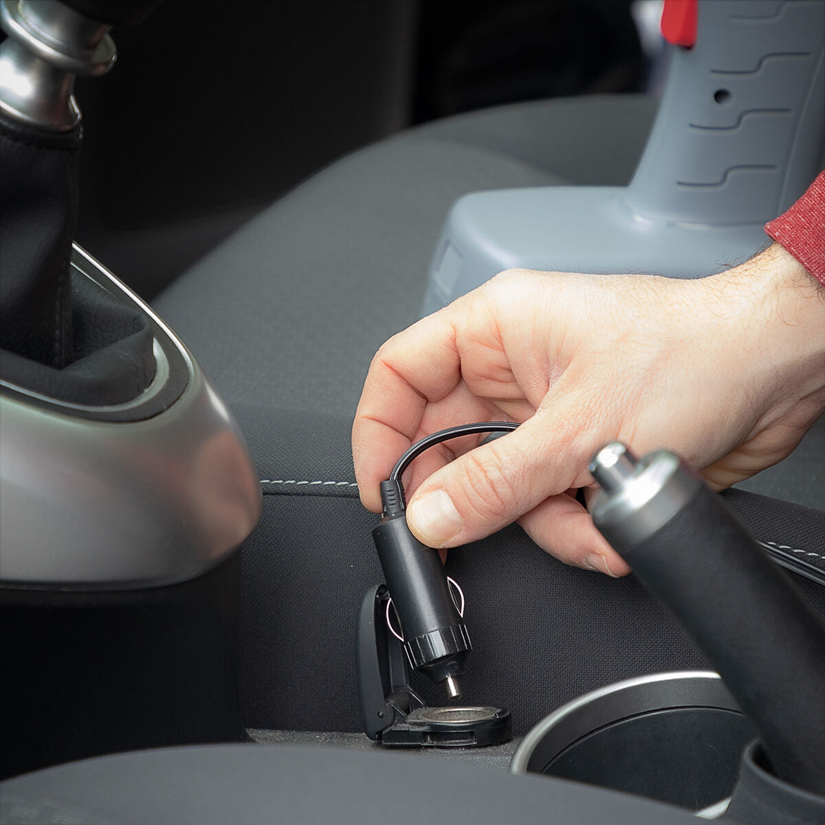 12-V-Stecker des Airpro+ Kompressors an einer Fahrzeugsteckdose