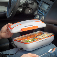 Geöffnete weiß-orange Pro Bentau Lunchbox mit dreigeteilter Mahlzeit im Fahrzeug