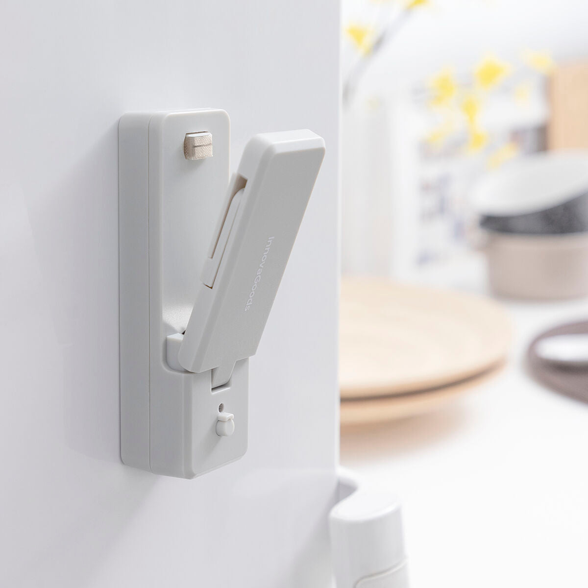 Grauer InnovaGoods Rebasyl haftet aufgeklappt an einer hellen Kühlschrankoberfläche