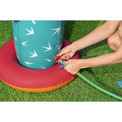 Hände verbinden einen grünen Gartenschlauch mit dem roten Anschlussadapter des Bestway Kaktus-Wassersprinklers
