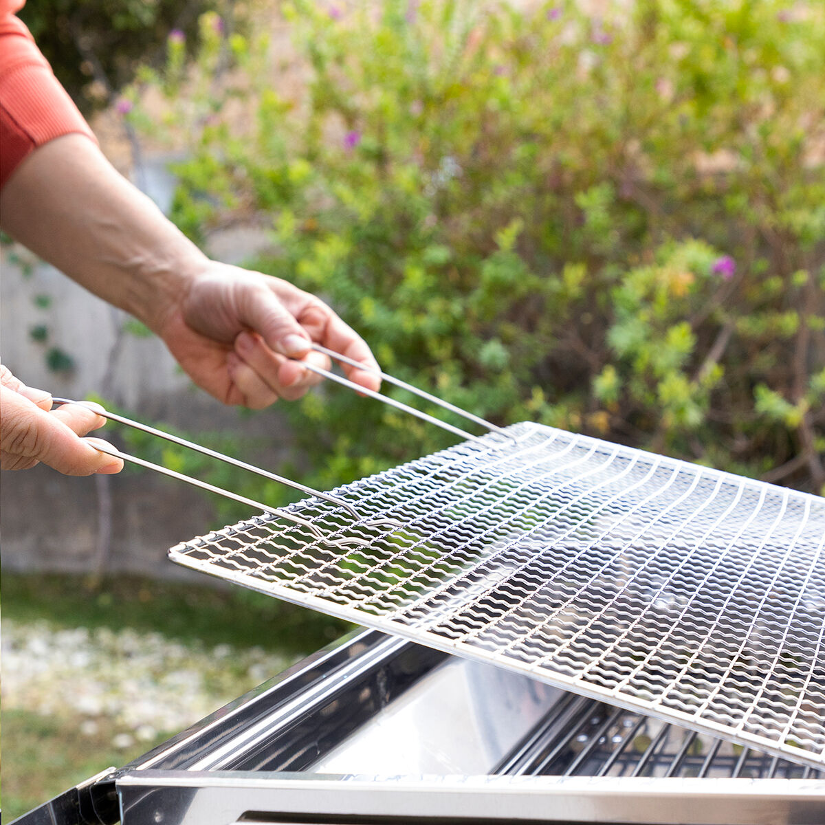 Oberer ExelQ-Grillrost mit zwei Griffen wird angehoben