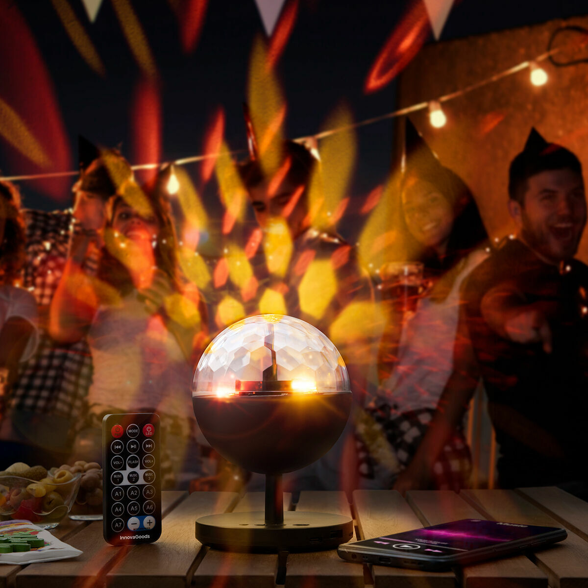 Istarlyt-Discokugel mit bunten Lichteffekten, Fernbedienung und Smartphone bei einer Feier