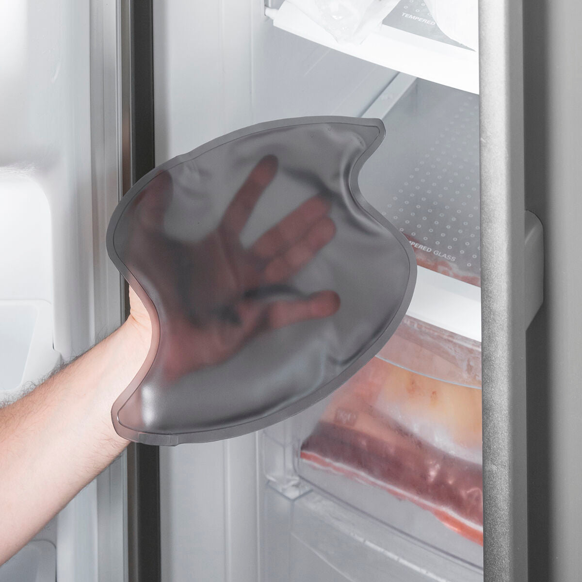 Separates Gelkissen vor einem geöffneten Gefrierfach